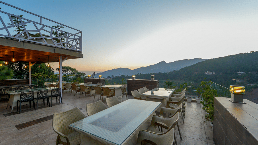 The open dining area set up with chairs and tables on the terrace at DLS Whispering Winds